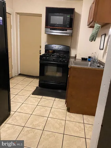 a kitchen with granite countertop a stove a microwave and a refrigerator