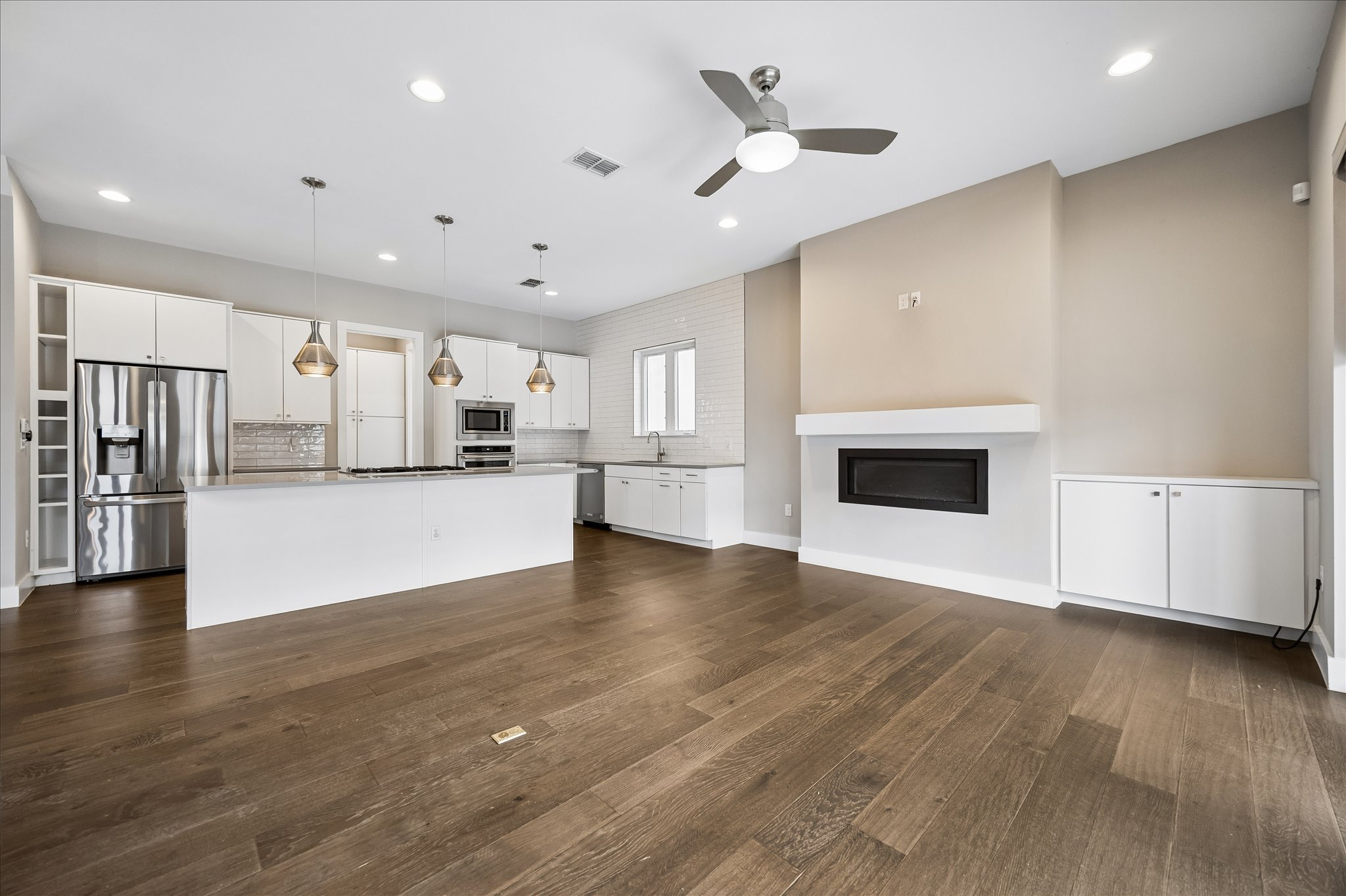5006 Pecan Springs Road, Unit 6 Austin, TX 78723 - Photo 9 of 30 An open concept living area boasts a modern kitchen and a cozy fireplace, perfect for entertaining.