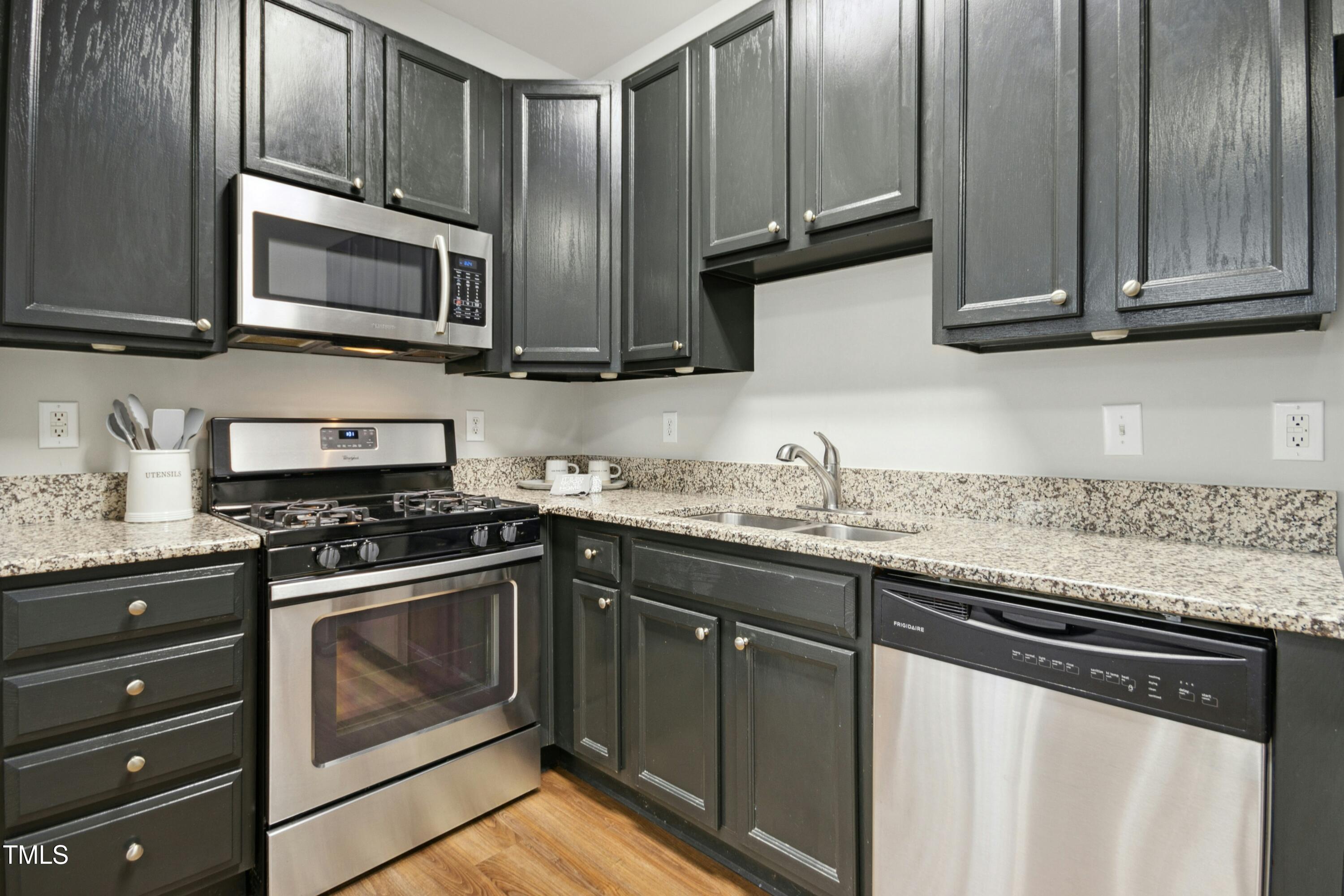 2225 Raven Road, Unit 107 Raleigh, NC 27614 - Photo 11 of 35 a kitchen with stainless steel appliances granite countertop a sink stove and microwave
