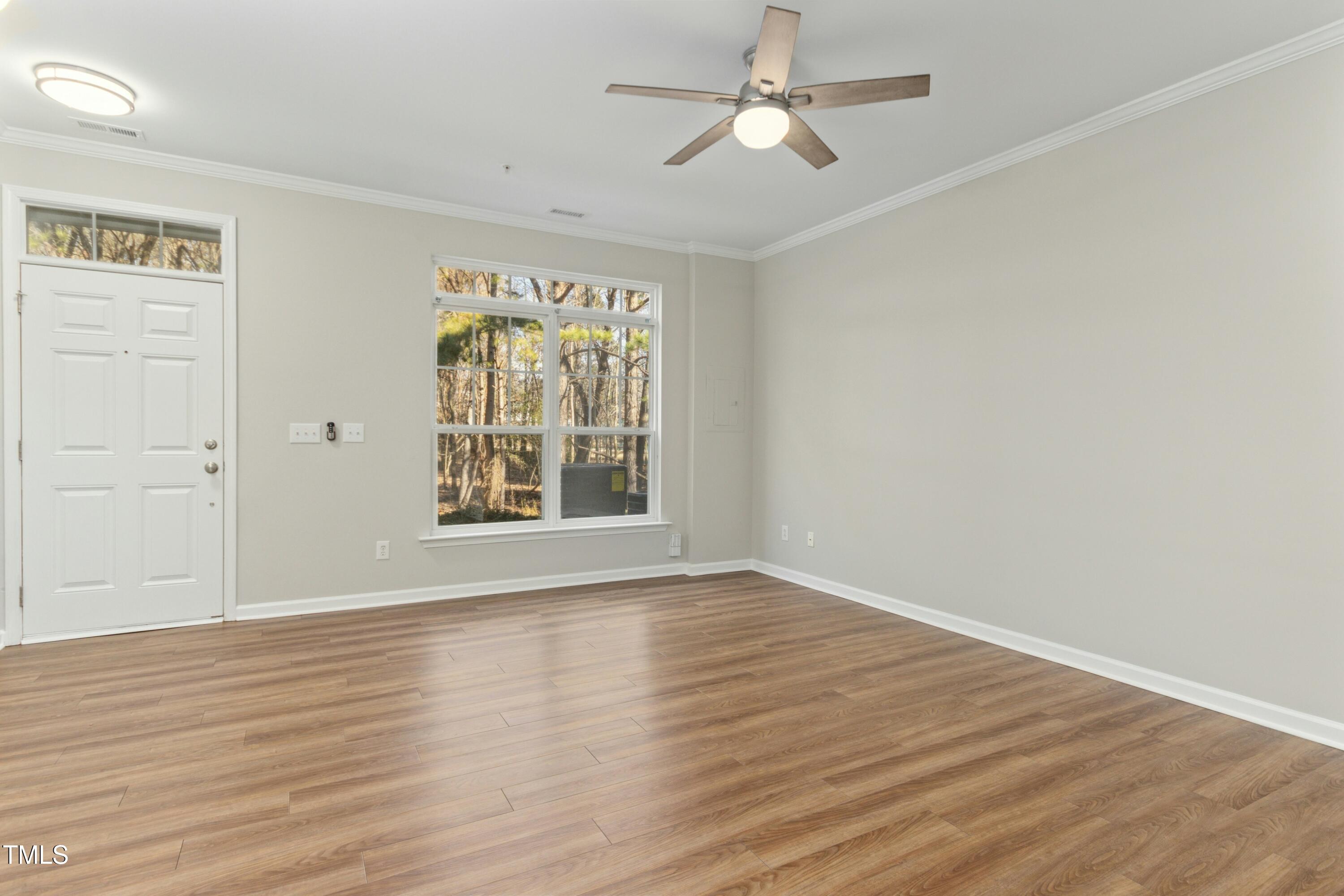 2225 Raven Road, Unit 107 Raleigh, NC 27614 - Photo 4 of 35 a view of an empty room with wooden floor and a window