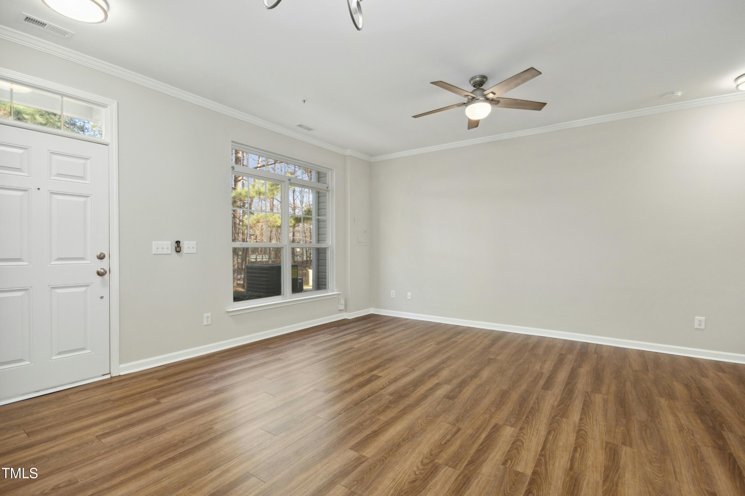 2225 Raven Road, Unit 107 Raleigh, NC 27614 - Photo 5 of 35 a view of an empty room with wooden floor and a window