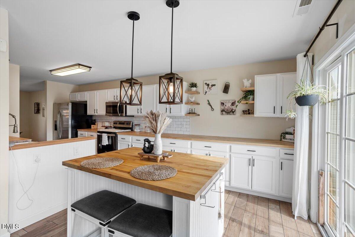 205 Battery Way Bunnlevel, NC 28323 - Photo 13 of 37 a kitchen with stainless steel appliances kitchen island a counter space and chairs