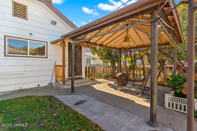 a backyard of a house with barbeque oven table and chairs