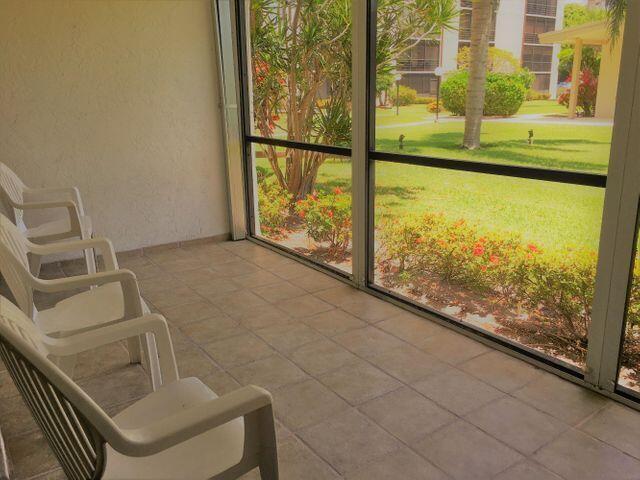 555 Banyan Tree Lane, Unit 109 Delray Beach, FL 33483 - Photo 11 of 17 a view of a room with wooden floor and windows