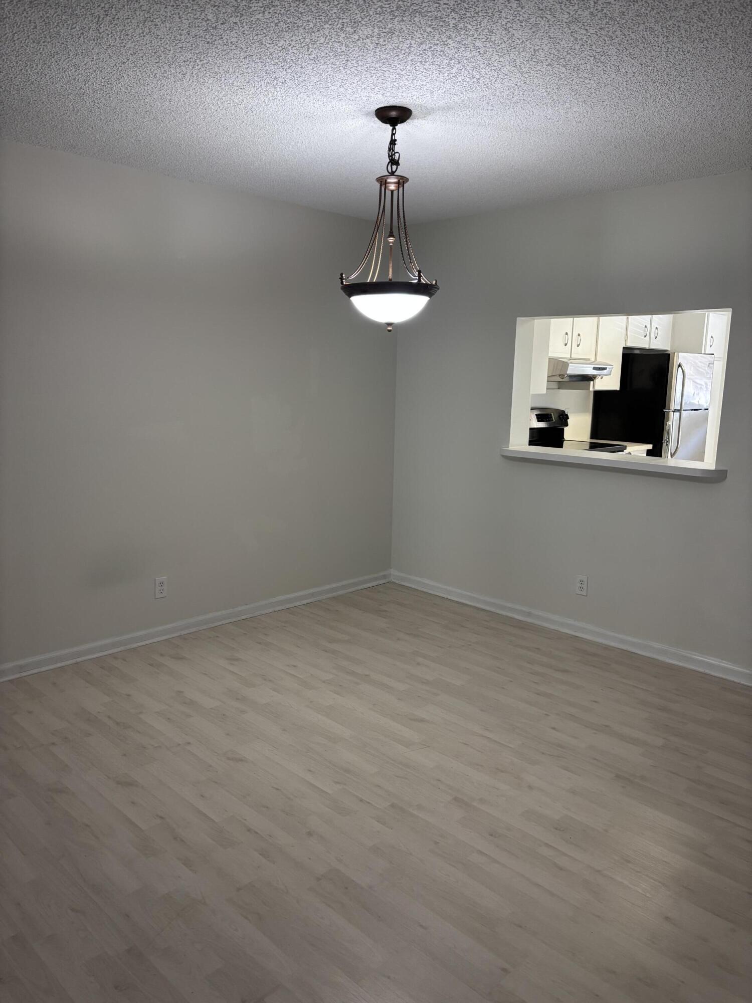 555 Banyan Tree Lane, Unit 109 Delray Beach, FL 33483 - Photo 17 of 17 a room with a chandelier fan and wooden floor