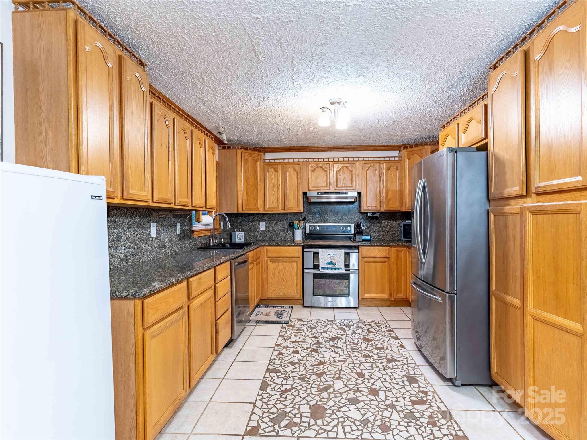 1000 Mountain View Church Road Zirconia, NC 28790 - Photo 9 of 22 a kitchen with stainless steel appliances granite countertop a refrigerator sink and cabinets