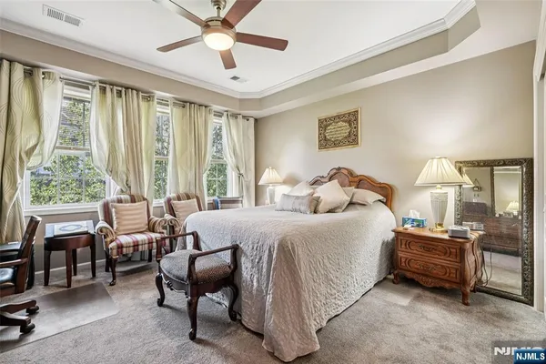 a spacious bedroom with a bed and a chandelier