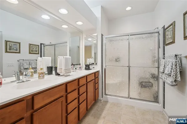 a bathroom with a double vanity sink mirror and shower