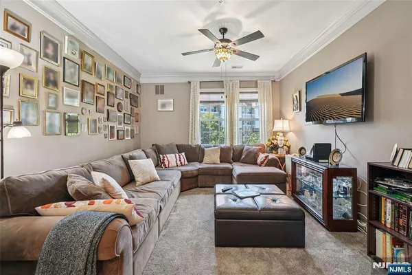 a living room with furniture a flat screen tv and a large window