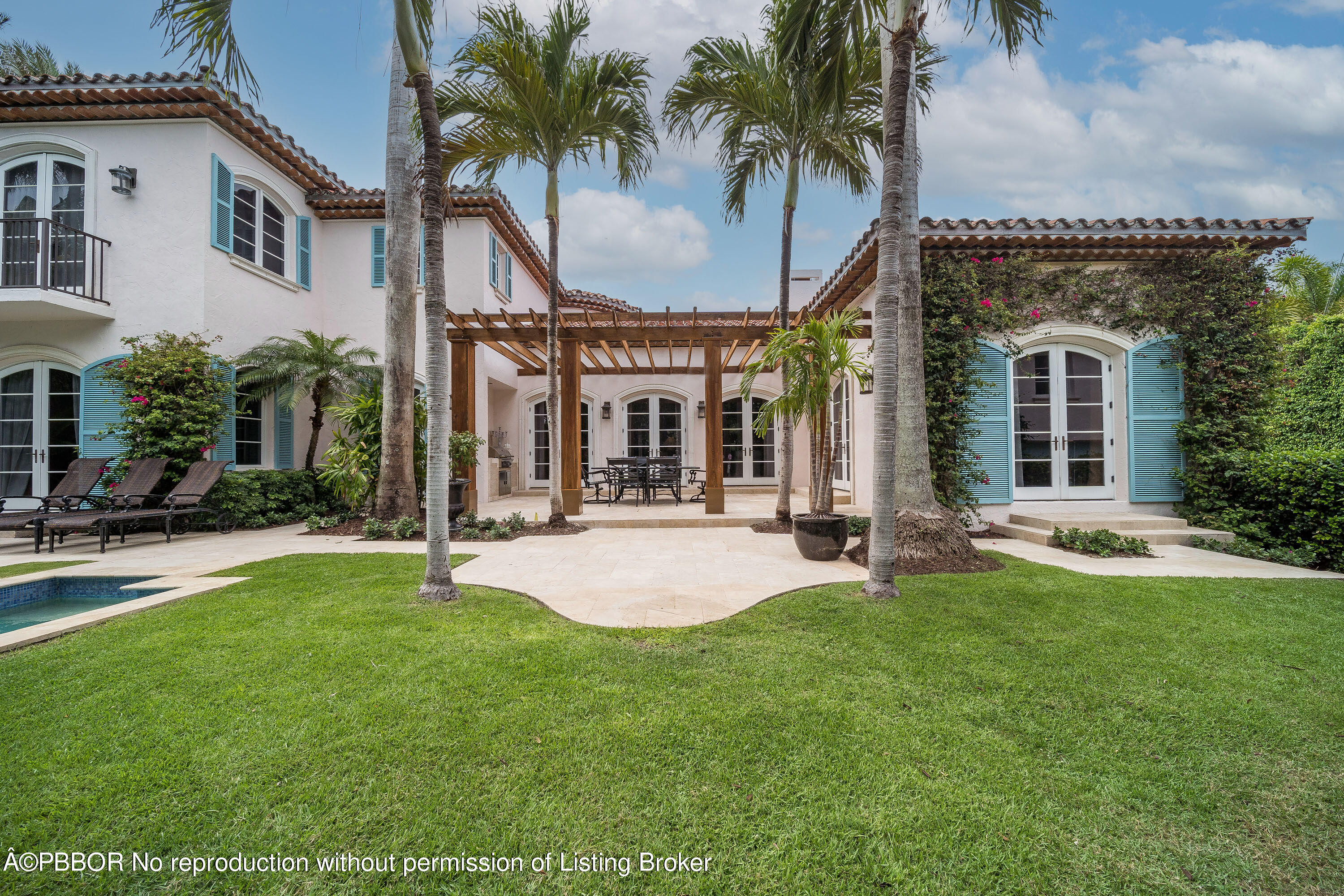 150 Woodbridge Road Palm Beach, FL 33480 - Photo 30 of 32 a view of a white house with a big yard and potted plants