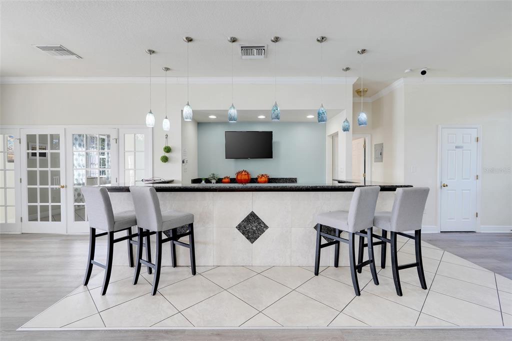 4312 Lake Underhill Road, Unit 19 Orlando, FL 32803 - Photo 30 of 43 a view of dining room and livingroom with furniture wooden floor a rug a flat screen tv a painting and a chandelier