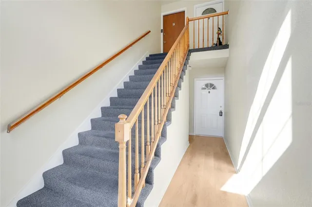 a view of staircase with wooden floor and white walls