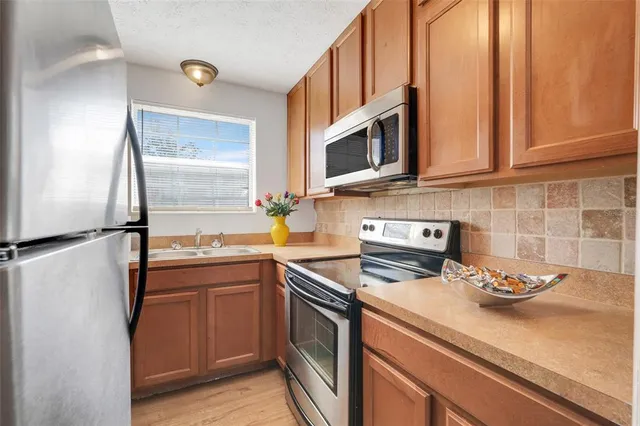 a kitchen with stainless steel appliances granite countertop a sink stove and microwave
