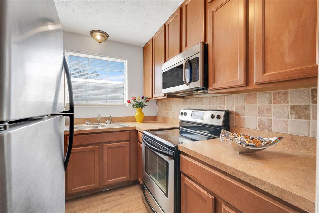 4312 Lake Underhill Road, Unit 19 Orlando, FL 32803 - Photo 5 of 43 a kitchen with stainless steel appliances granite countertop a sink stove and microwave