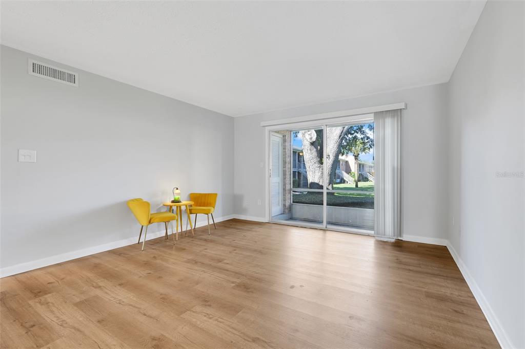 4312 Lake Underhill Road, Unit 19 Orlando, FL 32803 - Photo 9 of 43 a view of an empty room with wooden floor and a window