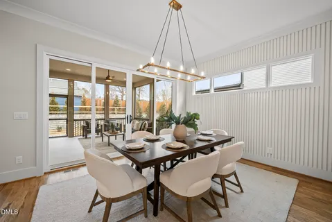 a dining room with furniture a chandelier and wooden floor