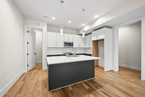 a large kitchen with stainless steel appliances granite countertop a sink stove and refrigerator