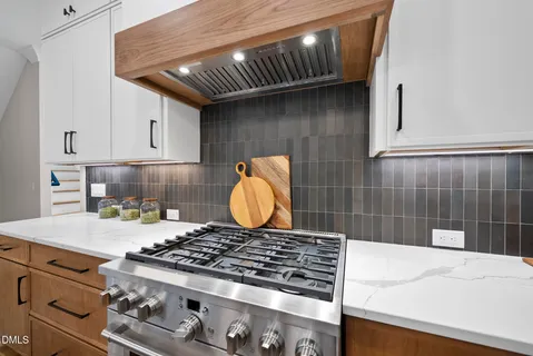 a kitchen with a stove and white cabinets