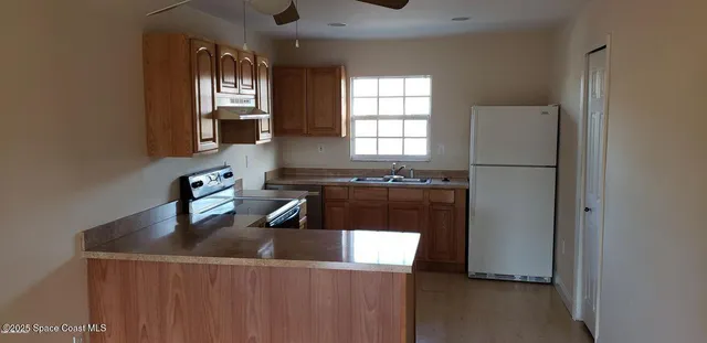 a kitchen with a refrigerator a sink and a window