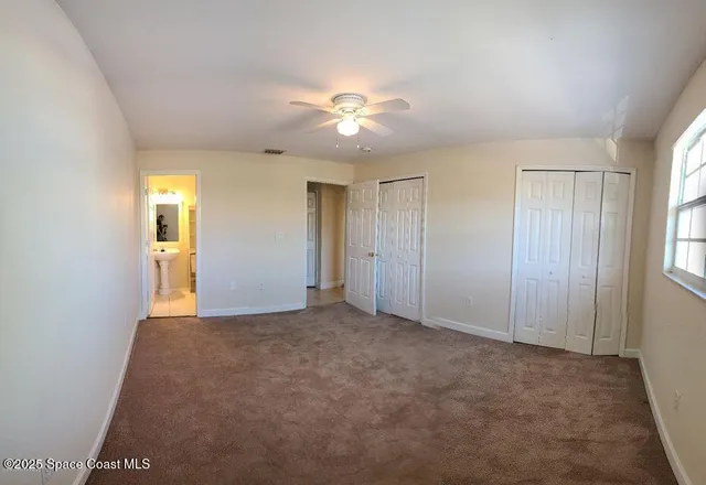 a view of an empty room with a ceiling fan