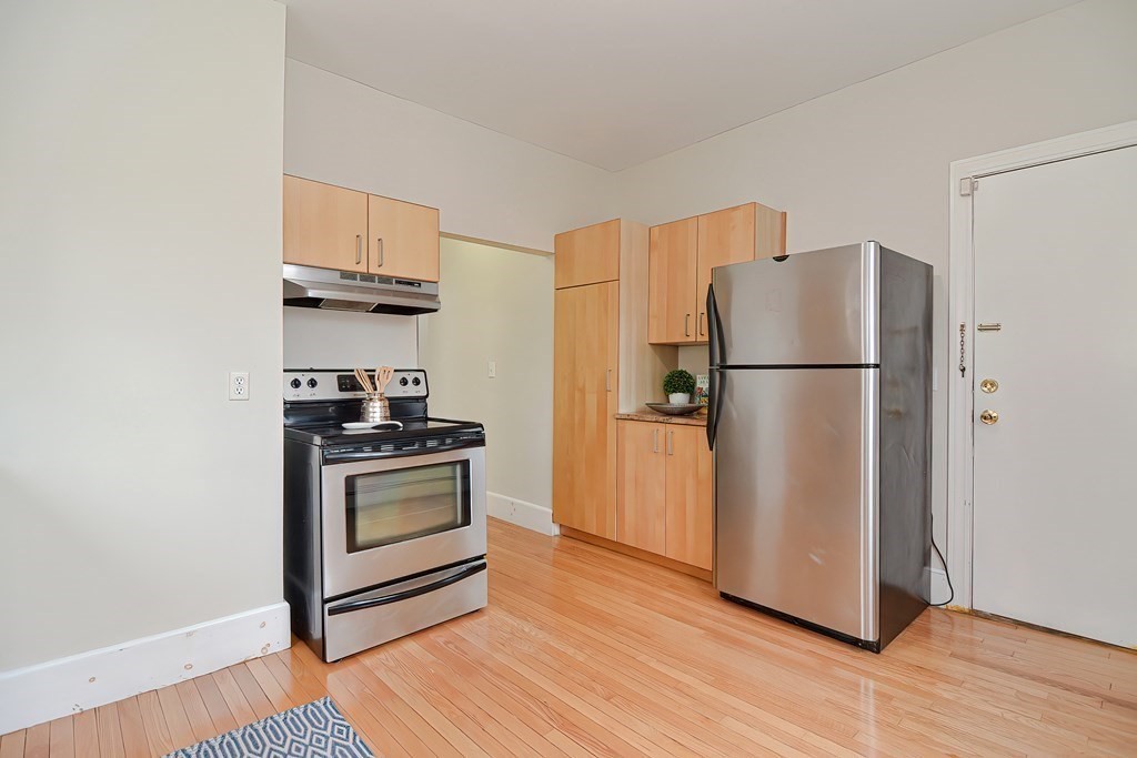 87 Broad Street, Unit 2 Lynn, MA 01902 - Photo 17 of 28 a kitchen with a refrigerator stove and wooden floor