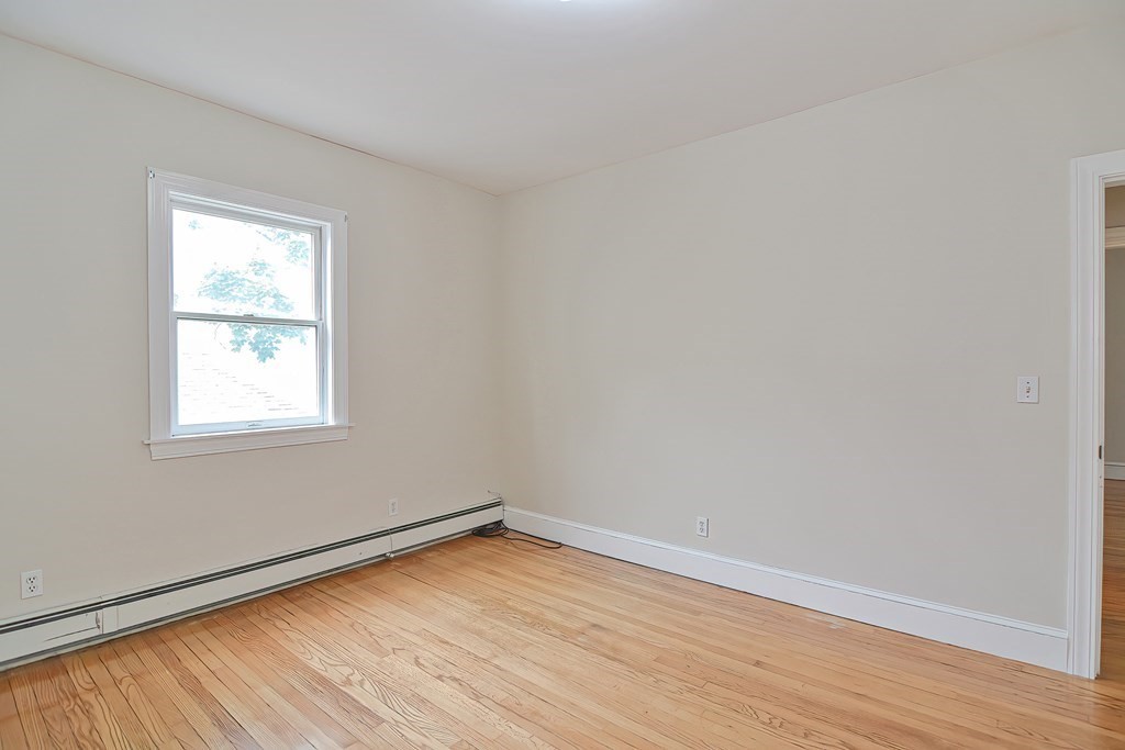 87 Broad Street, Unit 2 Lynn, MA 01902 - Photo 21 of 28 an empty room with wooden floor and windows