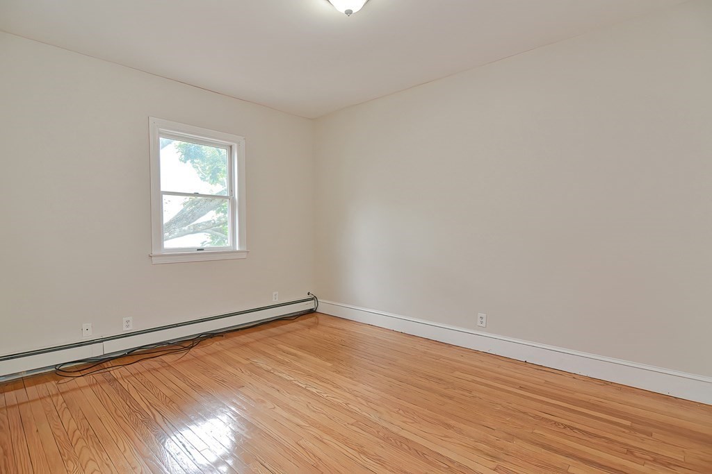 87 Broad Street, Unit 2 Lynn, MA 01902 - Photo 24 of 28 an empty room with wooden floor and windows