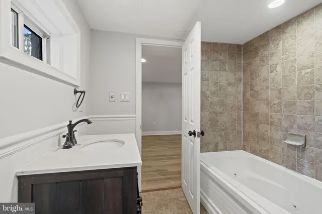 a bathroom with a sink a mirror and a bathtub