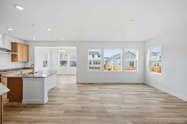 a view of kitchen with stainless steel appliances granite countertop a stove and a sink