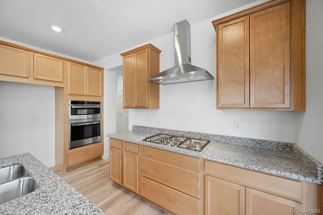 a kitchen with stainless steel appliances granite countertop a stove a sink and a refrigerator