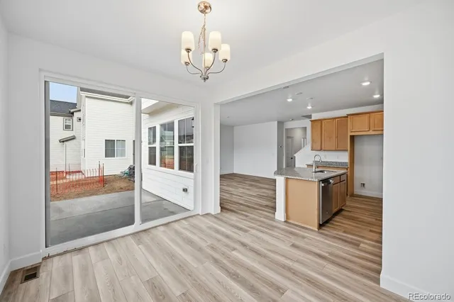 a large white kitchen with granite countertop a large counter top and stainless steel appliances