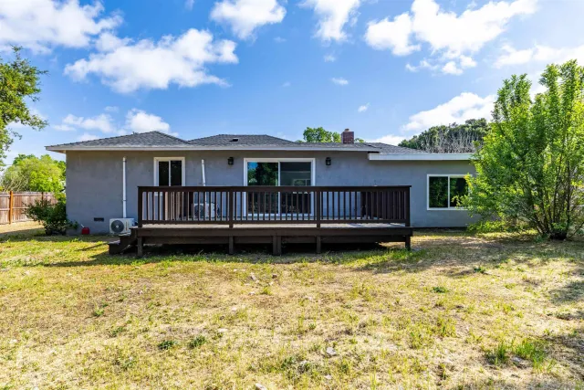 a view of a house with a yard wooden fence and a bench
