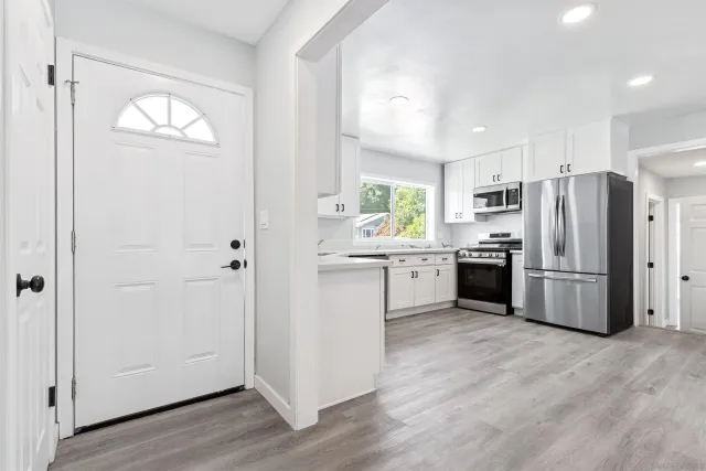 a kitchen with a refrigerator a sink and a stove top oven