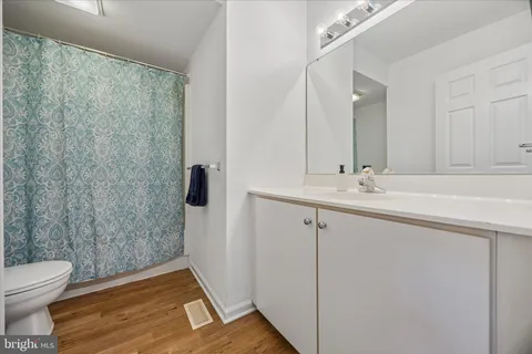 a bathroom with a sink a toilet a mirror and shower