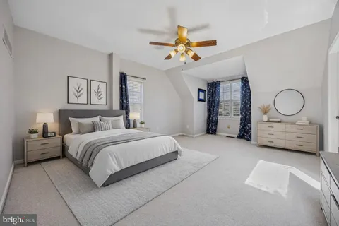 a spacious bedroom with a bed a window and a chandelier