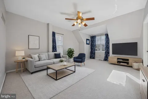 a living room with furniture a flat screen tv and a window