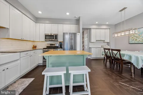 a kitchen with kitchen island wooden cabinets and stainless steel appliances