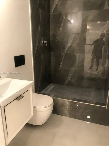 a bathroom with a granite countertop sink a toilet and a shower