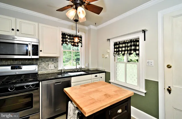 a kitchen with stainless steel appliances kitchen island a stove a sink and a microwave
