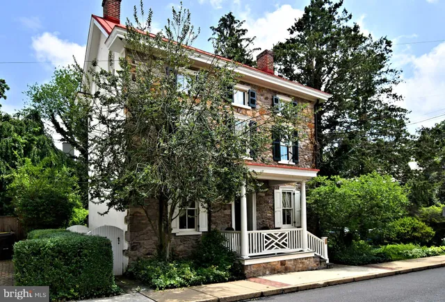 a front view of a house with a tree