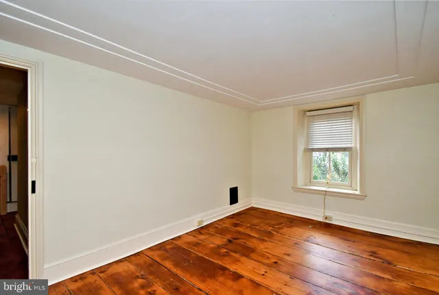 a view of a room with wooden floor and fan