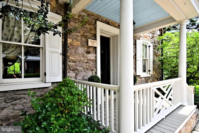 a view of a house with a small yard and wooden floor and fence