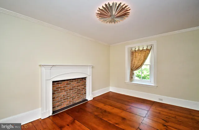 an empty room with windows closet and fireplace