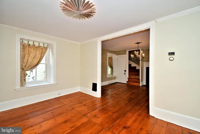 an empty room with wooden floor and a window