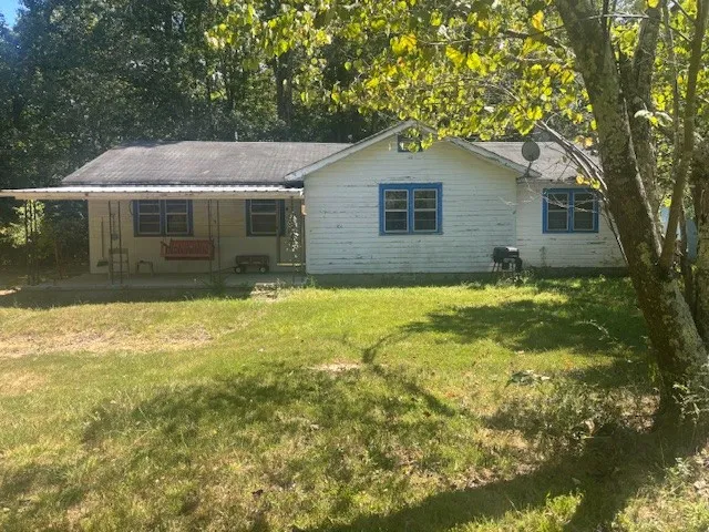 a backyard of a house with yard and outdoor seating