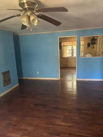 a view of an empty room with window and wooden floor