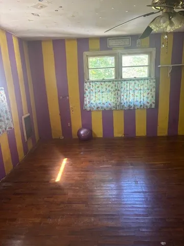 a view of a room with wooden floor and windows