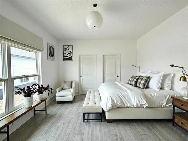 a bedroom with a bed and wooden floor