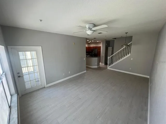 an empty room with windows and fan