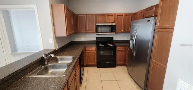 a kitchen with granite countertop a refrigerator and a sink